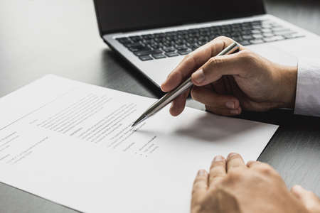 Managers are reviewing resumes of candidates who are interviewing for vacancies, he is looking at personal information and competence and education information to be considered for employment.の写真素材