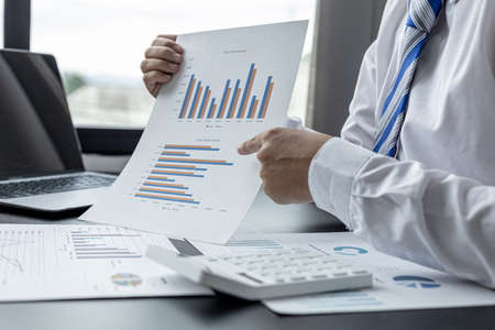 Businessmen are meeting together on company sales, they are business partners who open the company together, they are brainstorming and analyzing how to manage the company's sales growth.の写真素材
