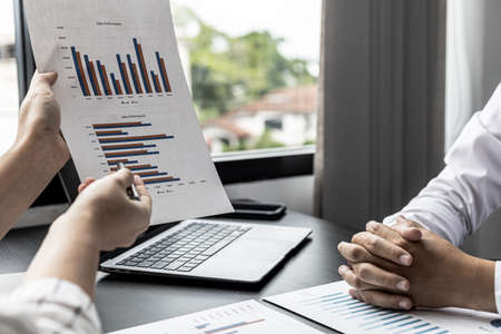 Two businessmen are meeting together on company sales, they are business partners who open the...