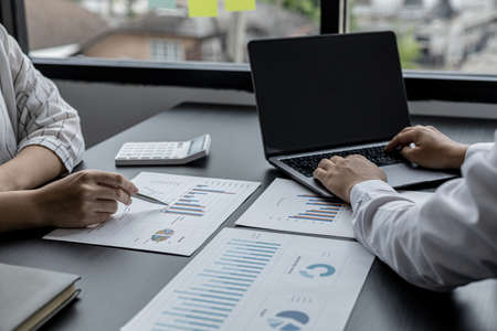 Two sales staff are working together to summarize monthly sales for the manager to review and bring in a meeting with the management to plan the company's sales management. Sales management concept.の写真素材