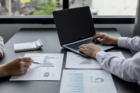 Two sales staff are working together to summarize monthly sales for the manager to review and bring in a meeting with the management to plan the company's sales management. Sales management concept.の写真素材