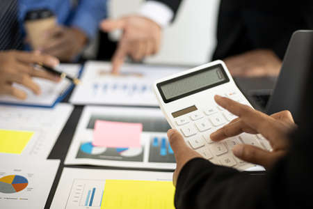 Close-up: Businessmen are pressing a calculator in a conference room where entrepreneurs and partners are meeting together, meeting summaries and brainstorming to help the company grow. Concept of busの写真素材