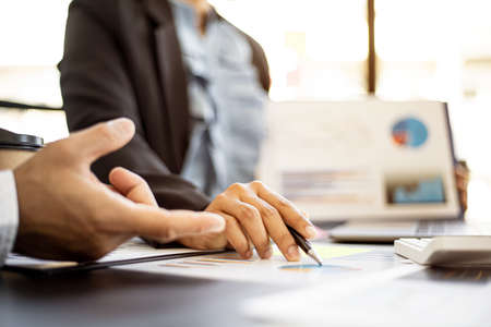 The finance department was meeting within the team before bringing the summary to the management again at the conference, a female employee discussing the company's financial chart. Financial concept.の写真素材