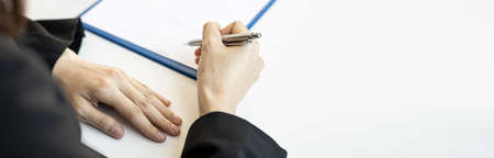 Close-up of a Businesswoman about to sign a real estate lease document, signing an important document contract. Banner background with copy space.の写真素材
