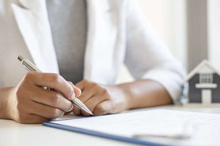 A housing project client is signing a housing purchase agreement, signing a purchase agreement to maintain the rights of each party when either party breaches the contract. real estate trading ideas.の写真素材