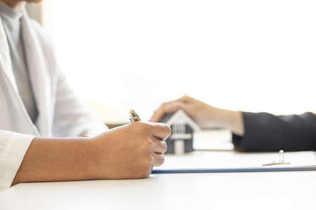A housing project client is signing a housing purchase agreement, signing a purchase agreement to maintain the rights of each party when either party breaches the contract. real estate trading ideas.の写真素材