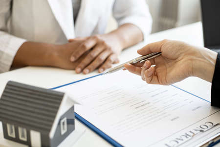 The home salesman and buyer is signing a purchase agreement after discussing the details, a contract to protect both parties' interests if the trade is not as agreed, Real estate trading ideas.の写真素材
