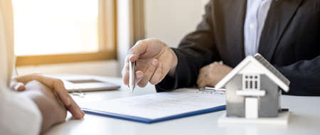 The home salesman and buyer is signing a purchase agreement after discussing the details, a contract to protect both parties' interests if the trade is not as agreed, Real estate trading ideas.の写真素材