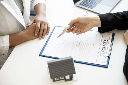 The home salesman and buyer is signing a purchase agreement after discussing the details, a contract to protect both parties' interests if the trade is not as agreed, Real estate trading ideas.の写真素材