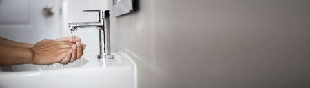 People washing their hands in the sink, washing their hands thoroughly is a precautionary measure against  infection. Everyone washes their hands regularly in the right way. copy space.の写真素材