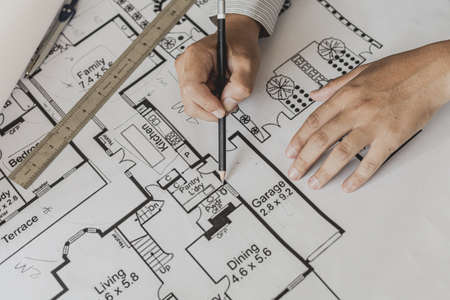 Architects write on the blueprints of the designed houses, designing the buildings according to the...