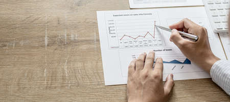 Financial scholars are looking at numbers on financial documents to verify the accuracy of company financial data, financial status documents line and pie charts. Finance concept.の写真素材