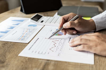 Financial scholars are looking at numbers on financial documents to verify the accuracy of company financial data, financial status documents line and pie charts. Finance concept.の写真素材