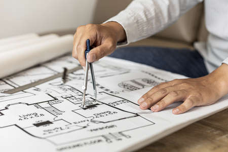 Architects use compasses to write on the blueprints of the houses, designing the buildings according to the standards and the law, designing the houses according to the needs of the residents.の写真素材