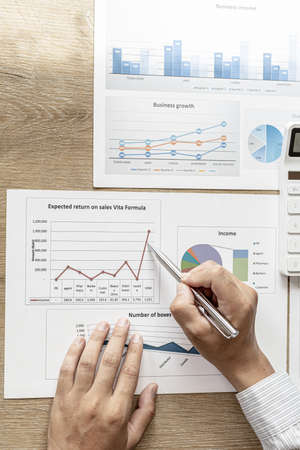 Financial scholars are looking at numbers on financial documents to verify the accuracy of company financial data, financial status documents line and pie charts. Finance concept.の写真素材