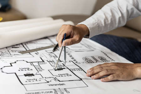 Architects use compasses to write on the blueprints of the houses, designing the buildings according to the standards and the law, designing the houses according to the needs of the residents.の写真素材