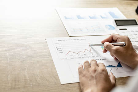 Financial scholars are looking at numbers on financial documents to verify the accuracy of company financial data, financial status documents line and pie charts. Finance concept.の写真素材