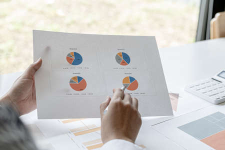 The sales manager points to the sales summary, she is checking the sales of each branch, she checks...