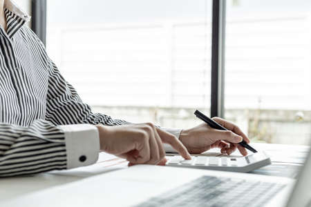 Businessman working in a private office, she is reviewing the company's financial documents sent...