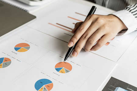 The auditor points to the financial statement, she examines the financial information from the documents prepared by the finance department, before presenting it at the meeting to the management.の写真素材