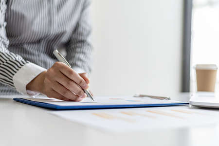 The auditor points to the financial statement, she examines the financial information from the...