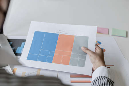 A businesswoman is looking at her schedule, she records it and prints it on paper as a reminder, she checks her schedule every morning. The idea of recording a schedule for reminders.の写真素材