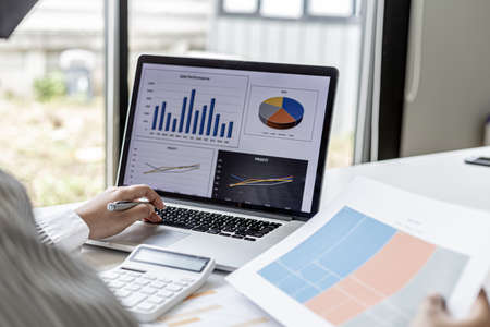 Businesswoman viewing financial data on laptop, she is reviewing financial data to bring to meetings...