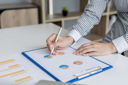 The auditor points to the financial statement, she examines the financial information from the...