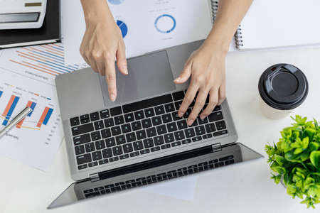 Businesswoman viewing financial data on laptop, she is reviewing financial data to bring to meetings...