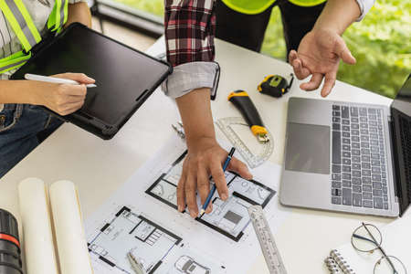 Architect engineers are standing by to look at the blueprints of the designed houses, they meet...