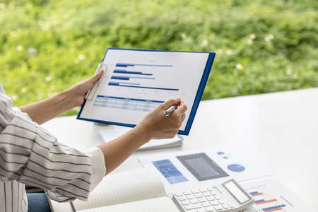 Business woman are looking at the company's financial documents to analyze problems and find solutions before bringing the information to a meeting with a partner. Financial concept.の写真素材