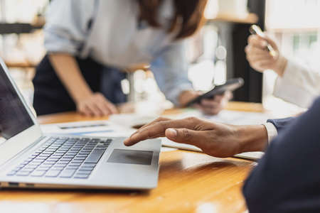 A business man uses a laptop to view presentations, the atmosphere of a startup company meeting room with executives and sales departments having a planning meeting. Sales management concept.の写真素材