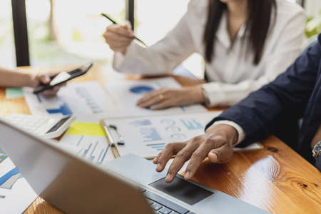 A business man uses a laptop to view presentations, the atmosphere of a startup company meeting room with executives and sales departments having a planning meeting. Sales management concept.の写真素材