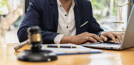 A lawyer man is seeking information on a fraud case to bring to court in a lawsuit from which a client has filed a lawsuit against an employee at a company that commits fraud. Fraud litigation conceptの写真素材