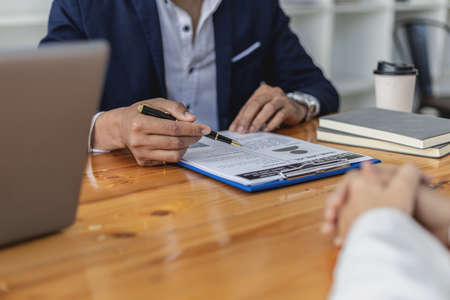 The HR manager is interviewing job applicants. He is reviewing the eligibility of applicants from her resume. Job interview ideas. The company is accepting employees for work and interview.の写真素材