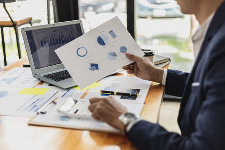 Business men are looking at the company's financial documents to analyze problems and find solutions before bringing the information to a meeting with a partner. Financial concept.の写真素材