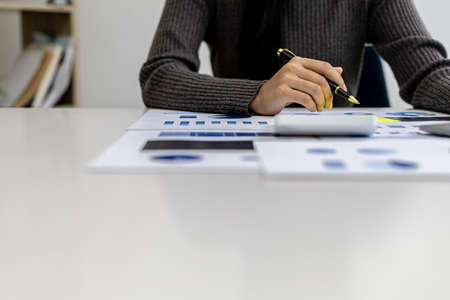 A business finance woman is reviewing a company's financial documents prepared by the Finance...