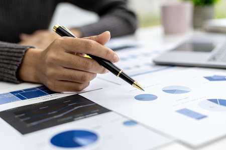 A business finance woman is reviewing a company's financial documents prepared by the Finance Department for a meeting with business partners. Concept of validating the accuracy of financial numbers.の写真素材