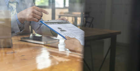 The HR department is reviewing the resumes of job applicants, resumes are important documents for job application. It should contain resume, training history, education, talent, work skills, etc.の写真素材