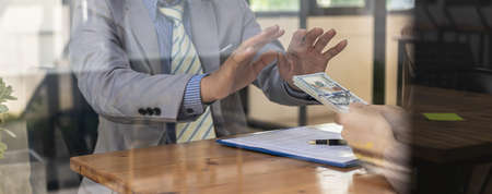 Two people are doing corrupt behavior, they are mutual business partners and are trying to bribe...
