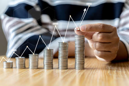 Women are stacking coins on top of the coin pile on the highest row. Placing coins in a row from low...