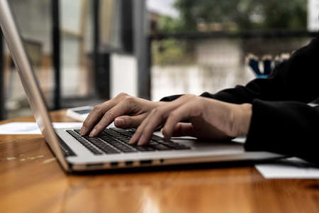 Close-up A business women working in a private room, She is typing on a laptop keyboard, She uses a...