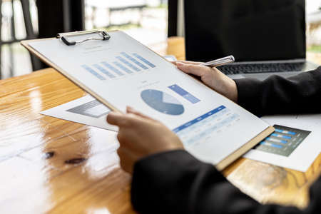 Business women are looking at the company's financial documents to analyze problems and find solutions before bringing the information to a meeting with a partner. Financial concept.の写真素材