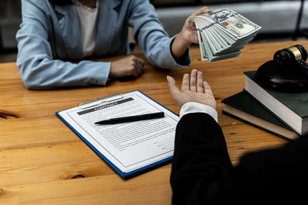 Two persons are committing unlawful fraud, the parties are filing a bribe of a lawyer to cause the client to lose the case. The concept of malpractice action.の写真素材