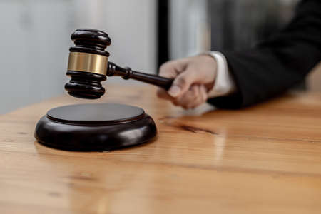 A person holding the hammer of justice, the concept of a lawyer or a law enforcement officer is...