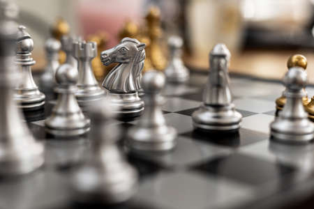 Close-up of horse chess pieces placed on a chessboard, concept comparing chessboard play to business...
