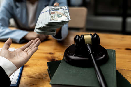 Two persons are committing unlawful fraud, the parties are filing a bribe of a lawyer to cause the client to lose the case. The concept of malpractice action.の写真素材