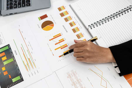 A business finance woman is reviewing a company's financial documents prepared by the Finance Department for a meeting with business partners. Concept of validating the accuracy of financial numbers.の写真素材