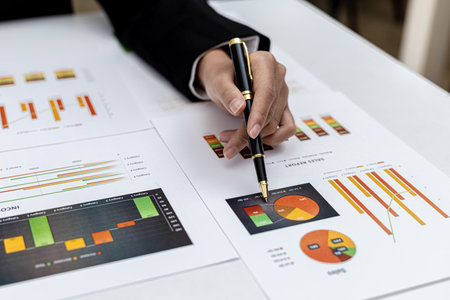 A business finance woman is reviewing a company's financial documents prepared by the Finance...