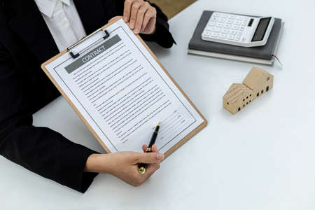 The salesperson is checking the contract before making an appointment for the customer to join the contract and explaining the details of the reward that the customer will receive. Real estate conceptの写真素材